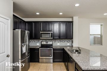 San Antonio house for rent - A kitchen with black cabinets and stainless steel appliances.