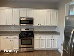 Acworth house for rent - a kitchen with stainless steel appliances and white cabinets