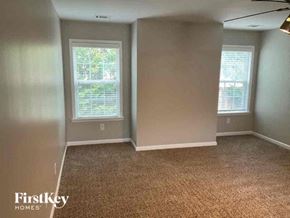 Acworth house for rent - a empty room with a carpeted floor and two windows