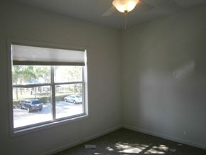 Bradenton house for rent - a bedroom with a large window and a lamp on the ceiling