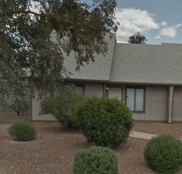 Tucson house for rent - A building with a grey roof and a brown fence.