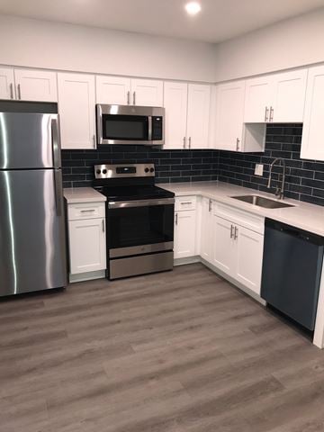 Phoenix apartment for rent - A kitchen with white cabinets and a black stove top oven.