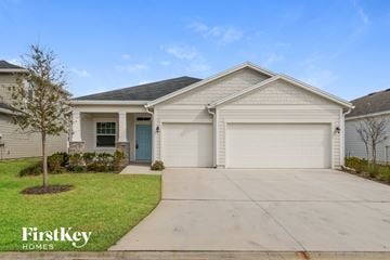 Jacksonville house for rent - a white house with a driveway and a garage door
