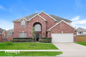 Pearland house for rent - a red brick house with a white garage door