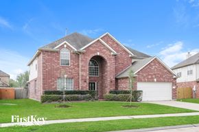 Pearland house for rent - a brick house with a lawn in front of it
