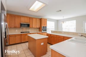 Pearland house for rent - a large kitchen with wooden cabinets and white counter tops
