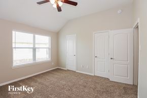 Pearland house for rent - a bedroom with two closets and a ceiling fan