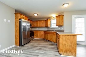 Clarksville house for rent - A kitchen with wooden cabinets and a stainless steel refrigerator.