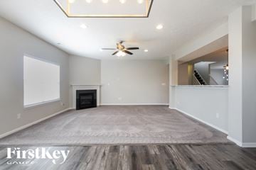 Greenfield house for rent - A spacious living room with a fireplace and a rug on the floor.