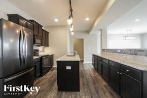 Greenfield house for rent - A kitchen with black cabinets and a FirstKey logo.