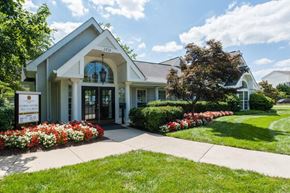Herndon apartment for rent - the front entrance of a white house with a sidewalk and flowers