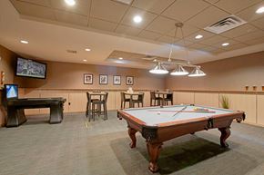 Minneapolis apartment for rent - A pool table in the middle of a room with a TV and tables.
