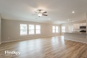 Richmond house for rent - A spacious room with wooden floors and a ceiling fan.