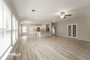 Richmond house for rent - A spacious room with a ceiling fan and wooden flooring.