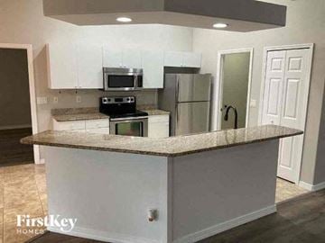 Cape Coral house for rent - a kitchen with a counter top and a refrigerator