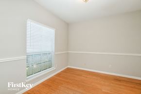 Garland house for rent - a bedroom with a large window and wood flooring
