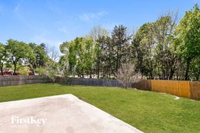 Garland house for rent - a backyard with grass and trees and a wooden fence