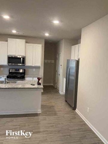 Auburn house for rent - a kitchen with white cabinets and a stainless steel refrigerator