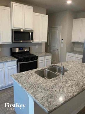 Auburn house for rent - a kitchen with white cabinets and a sink