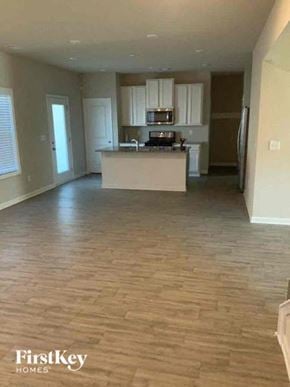 Auburn house for rent - an empty living room and kitchen with wood flooring