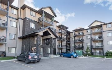 Edmonton apartment for rent - an apartment building with two cars parked in front of it