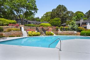 Smyrna apartment for rent - A swimming pool surrounded by a fence and trees.