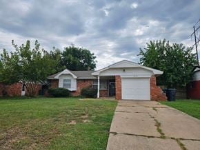 Oklahoma City house for rent - A house with a white garage door and a brick chimney.