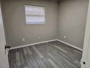Oklahoma City house for rent - A room with a wooden floor and a window with blinds.