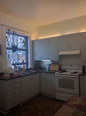 Ottawa apartment for rent - a kitchen with white cabinets and a stove and a window