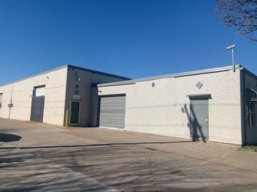 Garland apartment for rent - a white brick building with two garage doors