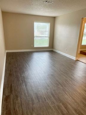 Pensacola house for rent - A room with wooden flooring and a window.