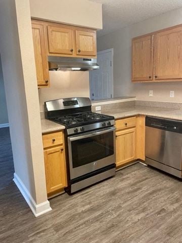 Pensacola house for rent - a kitchen with stainless steel appliances and wooden cabinets
