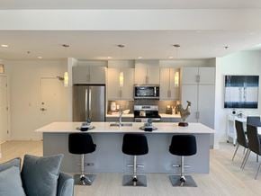 Winnipeg apartment for rent - a kitchen with an island and a bar with four chairs