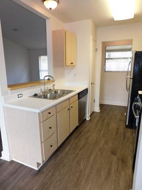 Pensacola house for rent - A kitchen with a sink, stove, and refrigerator.