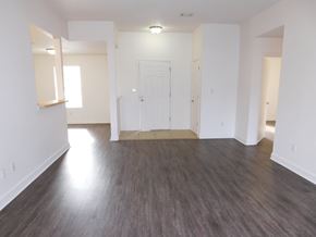 Pensacola house for rent - A room with a white door and a brown floor.