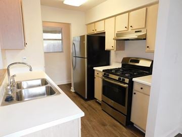 Pensacola house for rent - A kitchen with a black fridge, stove, and oven.