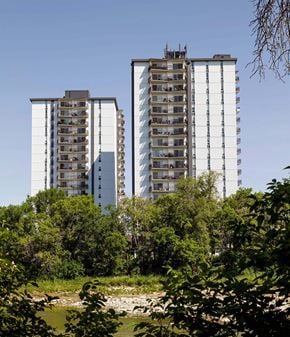 Winnipeg apartment for rent - two tall buildings with trees in the foreground and a river