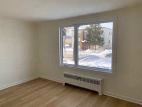 Winnipeg apartment for rent - a bedroom with a large window and a wood floor