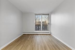 Ottawa apartment for rent - A room with a wooden floor and a sliding glass door.