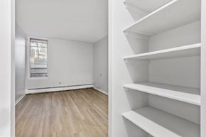 Ottawa apartment for rent - Empty room with white shelves and wooden floor.