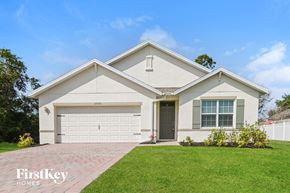 Cape Coral house for rent - a white house with a lawn and a garage door