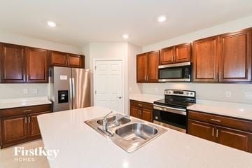 Cape Coral house for rent - a kitchen with wooden cabinets and stainless steel appliances and a white counter top
