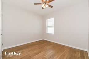 Cape Coral house for rent - a bedroom with wood floors and a ceiling fan