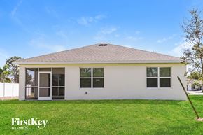 Cape Coral house for rent - the front of a white house with a yard and grass