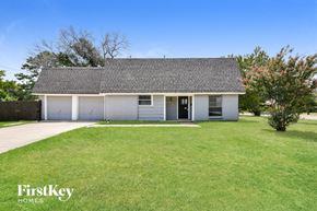 Irving house for rent - a small white house with a grassy yard and a driveway