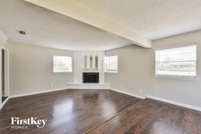 Irving house for rent - an empty living room with wood floors and a fireplace