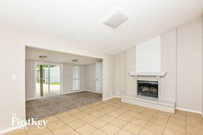 Fort Worth house for rent - A spacious living room with a fireplace and a skylight.