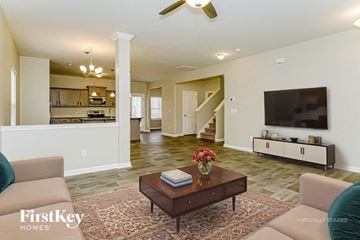 Wendell house for rent - A living room with a brown coffee table and a flat screen TV mounted on the wall.