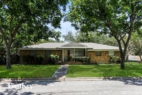 Waxahachie house for rent - A house with a green lawn and trees in front.