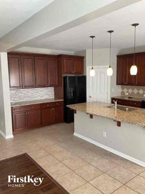 Charlotte house for rent - a kitchen with a marble counter top and wooden cabinets